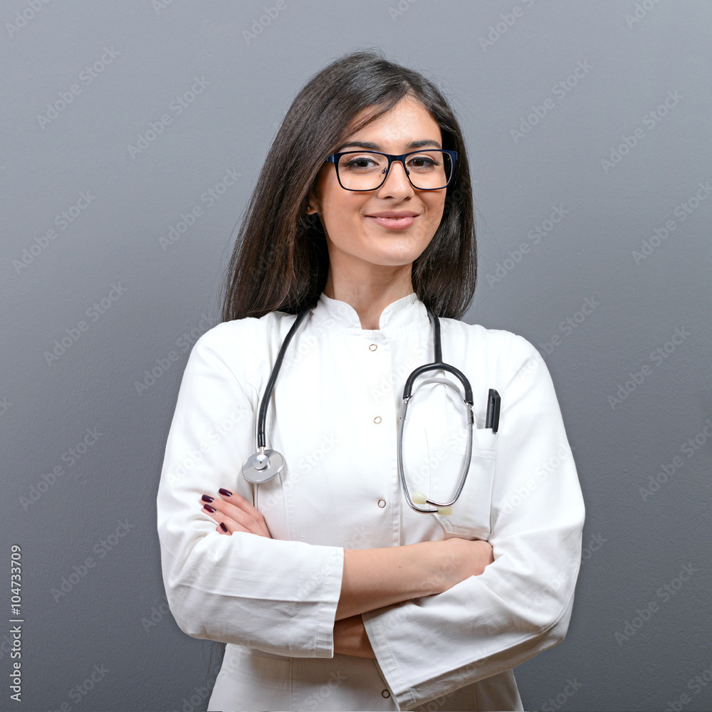 Smiling medical doctor woman with stethoscope against gray backg Smiling medical doctor woman with stethoscope against gray backg