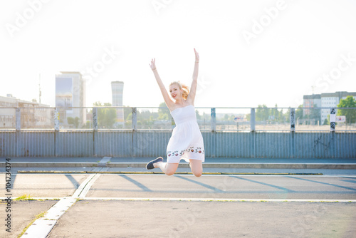 Young beautiful caucasian blonde hair woman jumping in the city