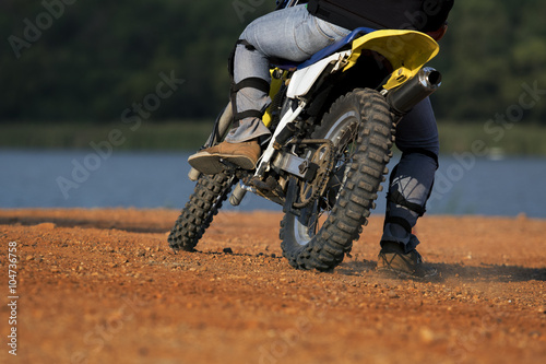 man riding enduro motorcycle on dirt field