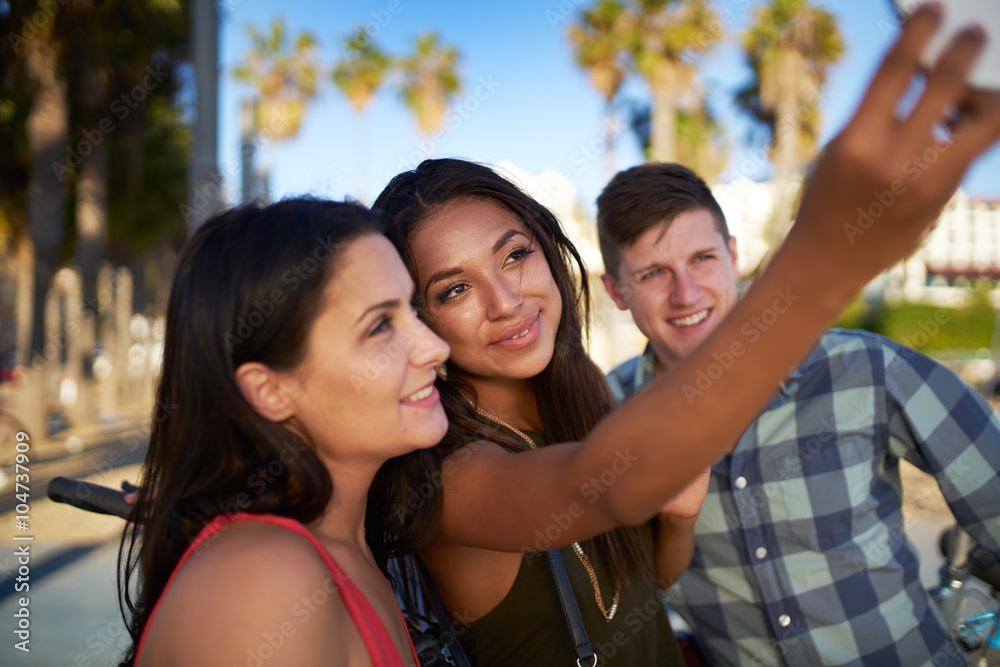 group of three friends taking selfies group of three friends taking selfies