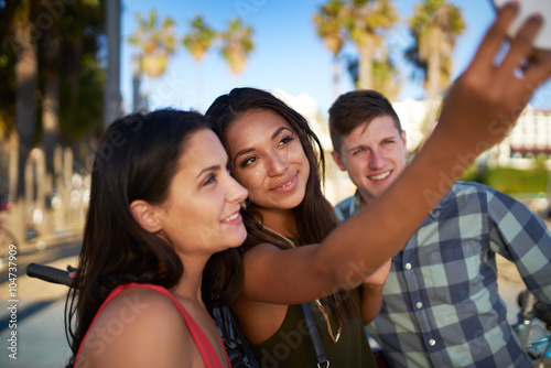 group of three friends taking selfies