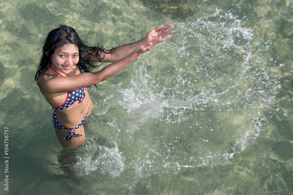 cheerful woman playful with water in the sea