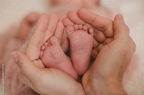 Newborn's feet in her mother's hands