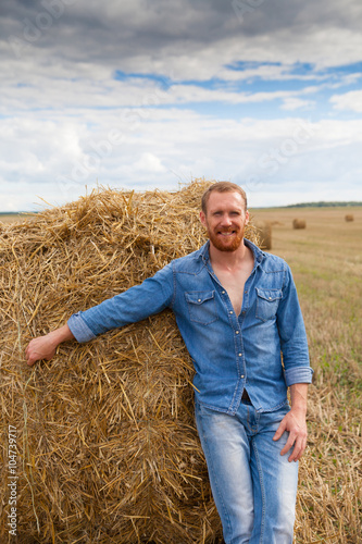 Man in jeans in   hay on  field. © DariaTrofimova