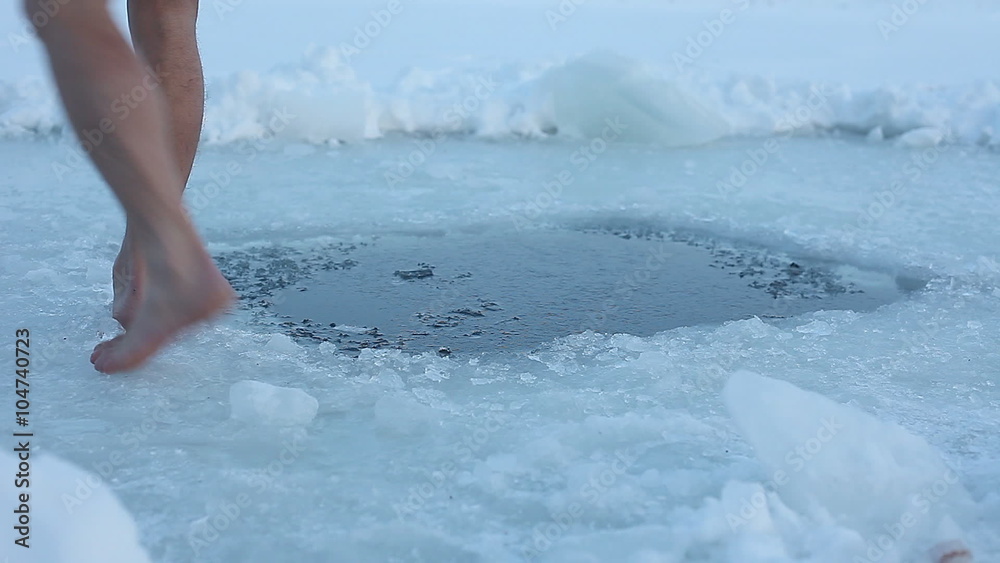 Young man having recreation swim in an ice hole Young man having recreation swim in an ice hole