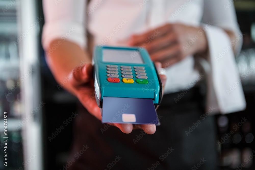 Bartender accepting a credit card at bar counter