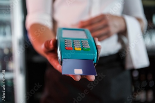 Fotografie Bartender accepting a credit card at bar counter