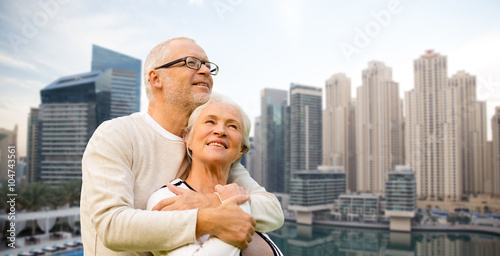 Canvas Print senior couple hugging over dubai city waterfront