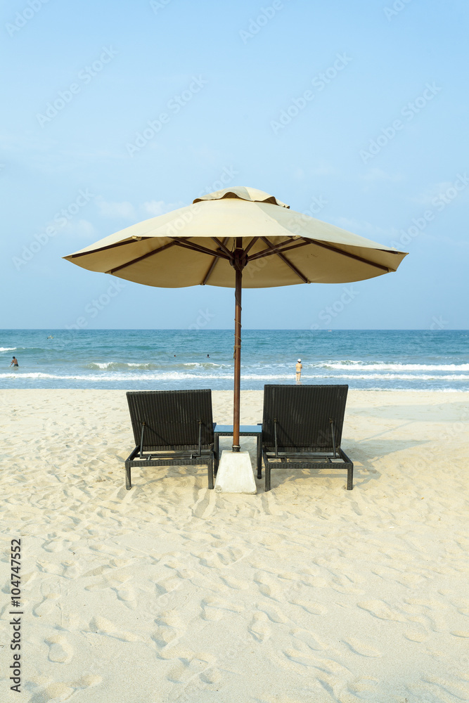 Lounger under an umbrella on the beach ocean