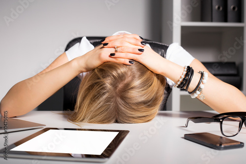 Tired business woman resting her head on desk photo