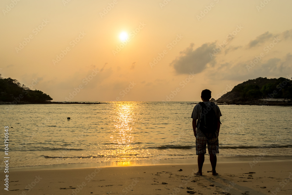 Young tourists stand and watch the sunrise in the morning at Choeng Mon Beach Koh Samui in Thailand.