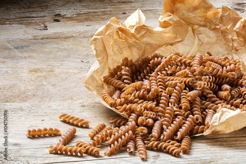 wholemeal pasta fusilli from organic whole grain spelt on a paper bag photo