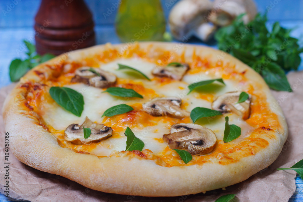 Italian food. Mediterranean cuisine. Delicious pizza with mushrooms and basil - thin pastry crust on wooden background.