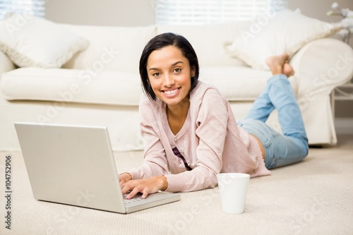 Smiling brunette using laptop