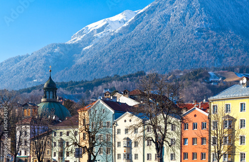  Austria, Innsbruck, the Mariahilf strasse colored houses on the Inn river with the snowy mountains in the background
