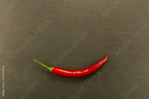 Red hot chili pepper on vintage black table. Colorful dried natural herbs and spices.