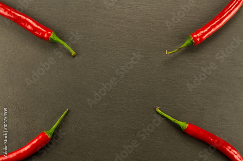 Red hot chili pepper on vintage black table. Colorful dried natural herbs and spices.