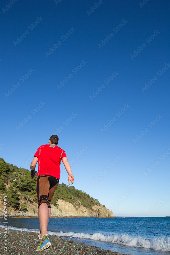 Man running on a rural road during sunset in the mountains