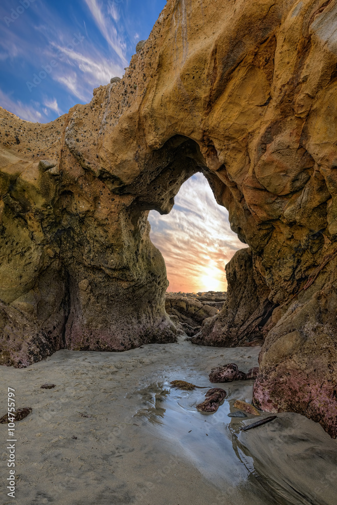 Doorway to the Sun - Years of pounding waves sculpted an archway in cliffs along the Pacific Ocean coast. As the sun sets in the West, the archway appears to be a doorway to the sun.