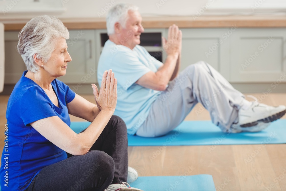 Senior couple performing yoga exercise Senior couple performing yoga exercise