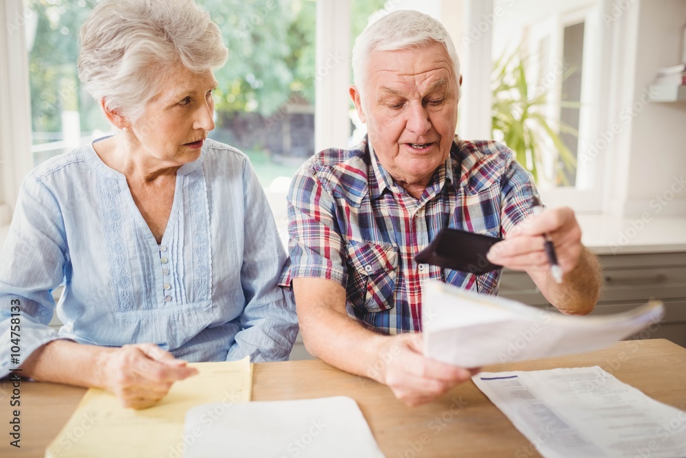 Worried senior couple checking their bills Worried senior couple checking their bills
