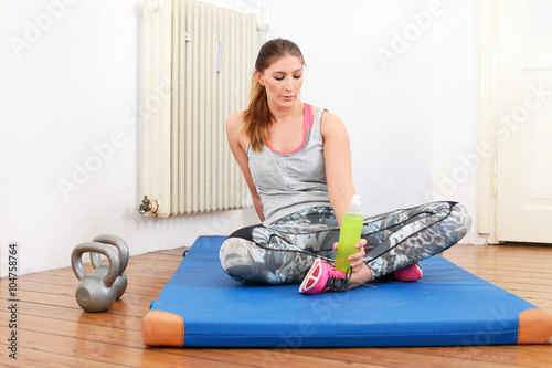 Frau macht Sport Pause mit Iso-Drink photo