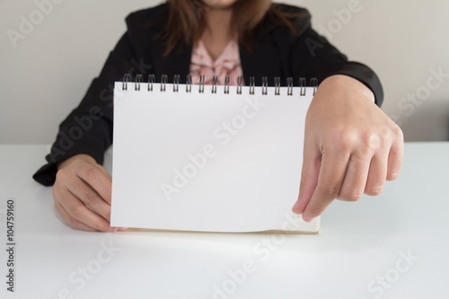Businesswoman hand turning page of notebook