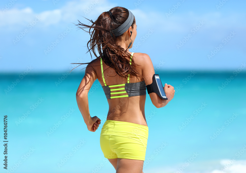 Running motivation - runner training with music seen from behind jogging in  fashion yellow straps sports bra and neon shorts outfit wearing wireless  earphones on summer beach background. Photos | Adobe Stock