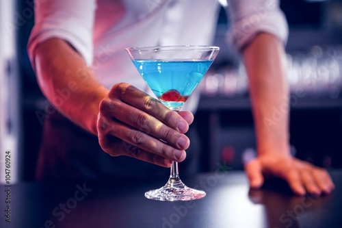 Bartender serving a blue martini