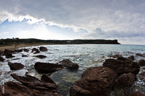 Sea rocks and waves at beach in San Pietro island, Sardinia, Italy