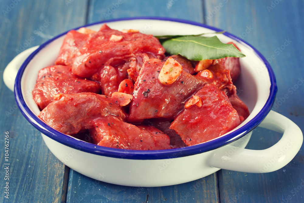 meat in marinate with garlic and bay leaf on dish meat in marinate with garlic and bay leaf on dish