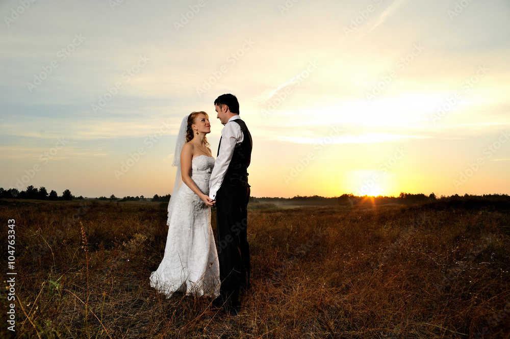 Bride and Groom in the Field at Sunset