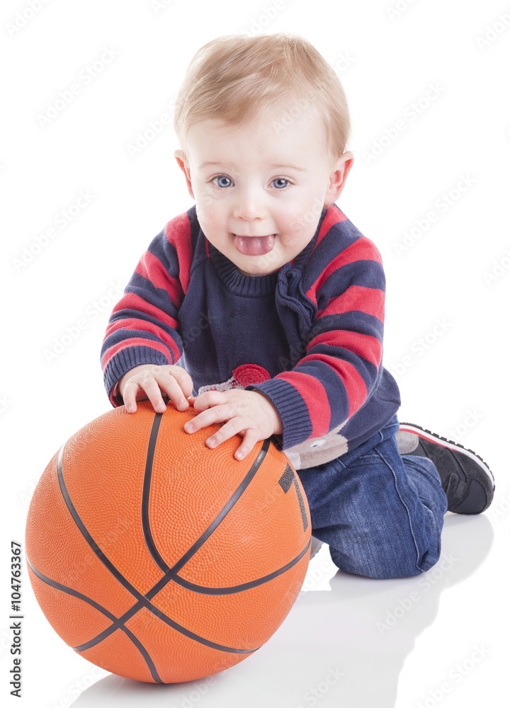 Casual baby playing with a basketball, isolated on white backgro