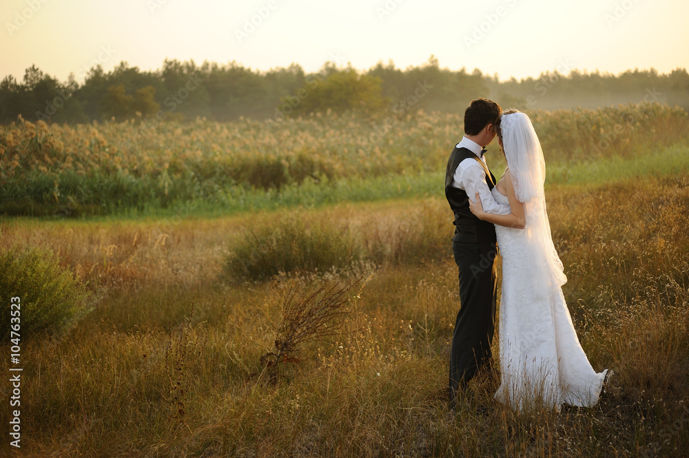 Bride and Groom in the Field at Sunset
