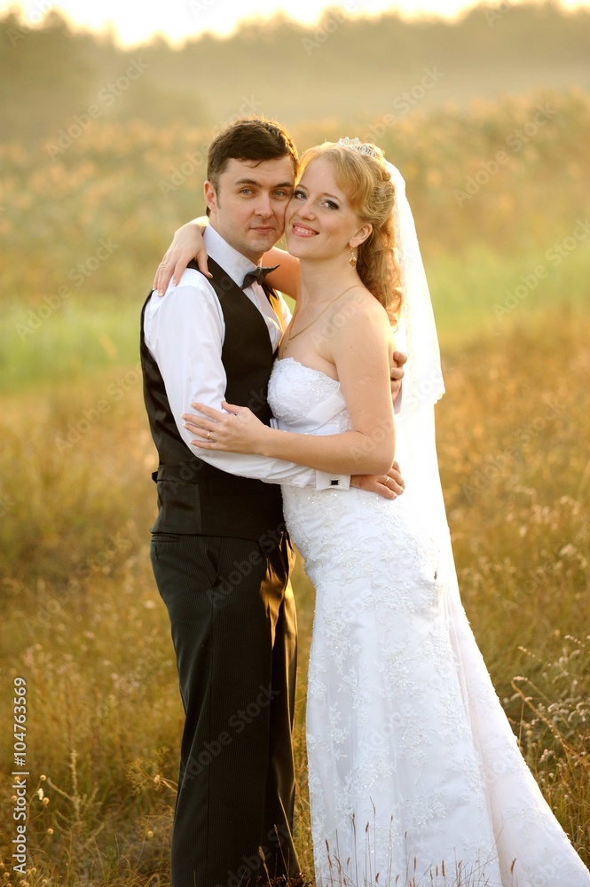 Bride and Groom in the Field at Sunset