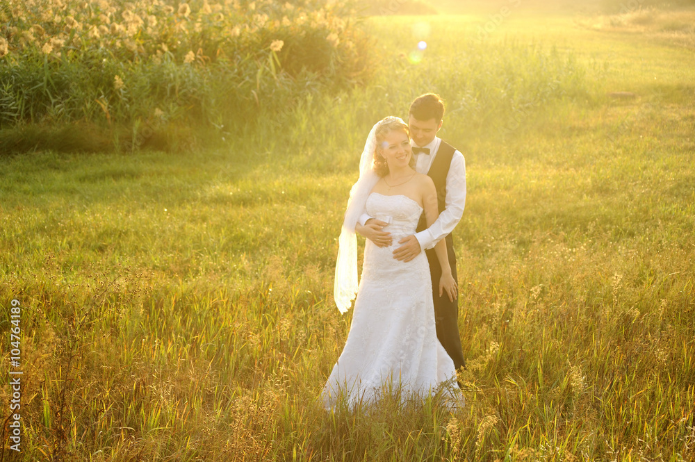 Bride and Groom Posing in the Field, filled with light