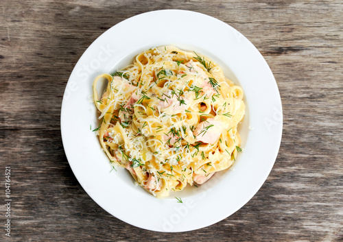tasty pasta with salmon, dill, cheese on plate.
