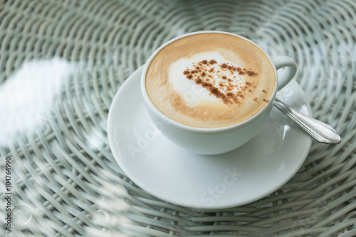 White cup of cappuccino stands on the table, selective focus