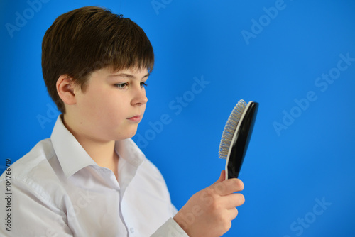 Boy teenager with comb in his hand photo