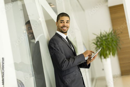 Young black man with tablet in the office