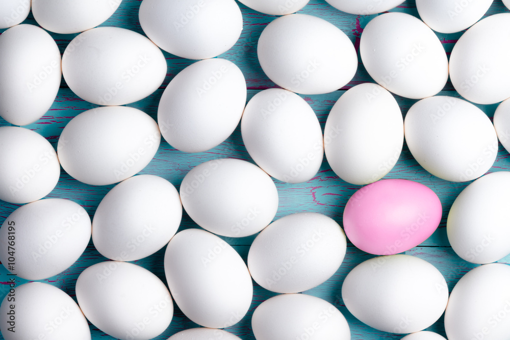Large number of white Easter eggs and one pink one Large number of white Easter eggs and one pink one