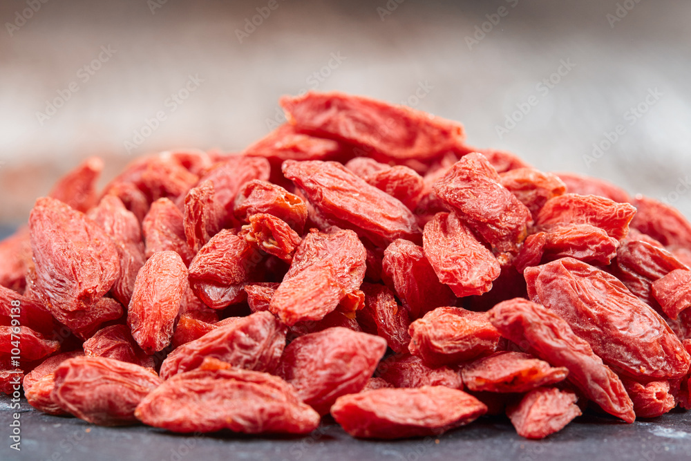 Pile of goji berries on a black stone plate Pile of goji berries on a black stone plate