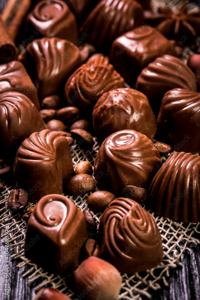 Delicious chocolate candies on wooden background