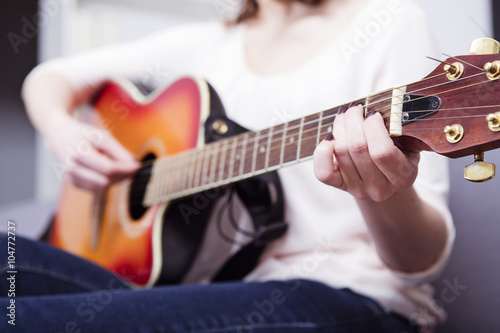 Pretty handsome woman playling some records on guitar , close up