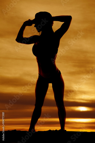 silhouette of woman in bikini and hat hands up