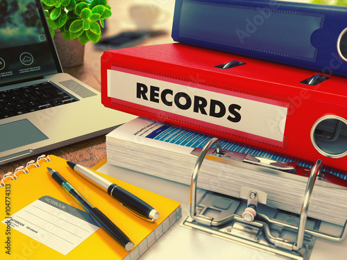 Red Office Folder with Inscription Records on Office Desktop with Office Supplies and Modern Laptop. Business Concept on Blurred Background. Toned Image. 3D Render.