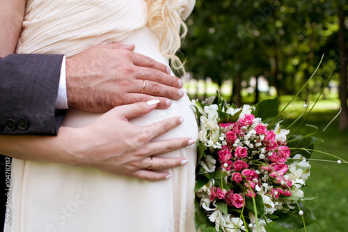 Wallpaper Mural Wedding couple hands with wedding ring on woman's pregnant belly Torontodigital.ca