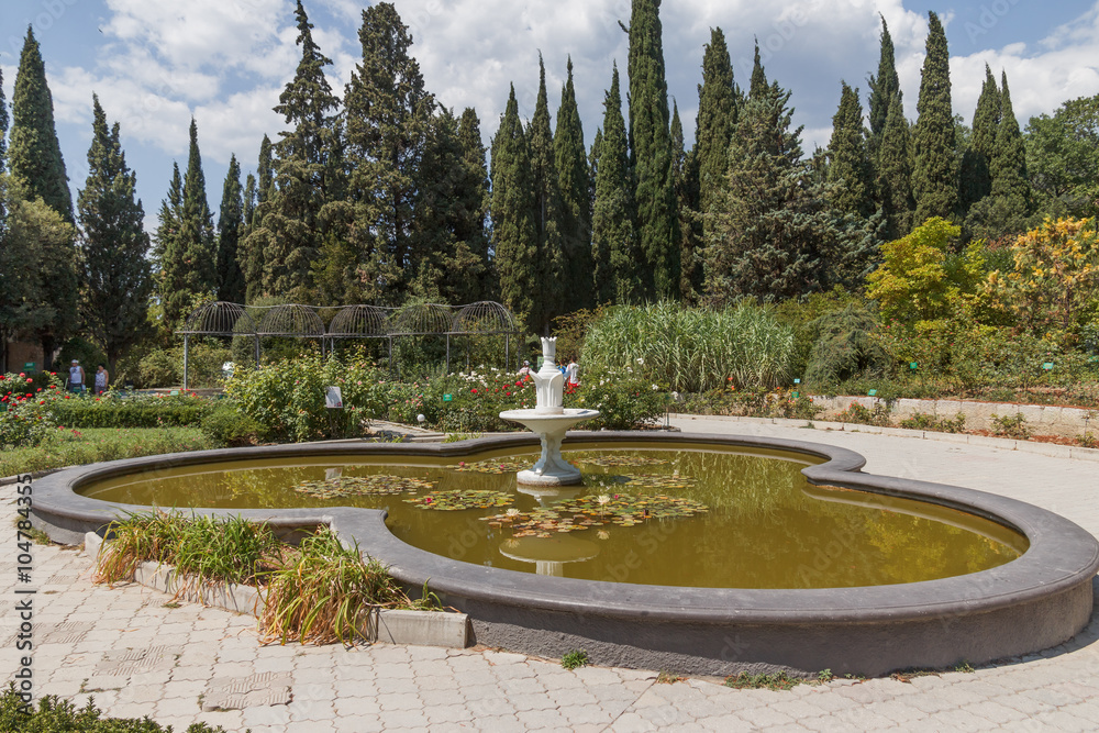 Crimea, Nikitsky Botanical Garden. Rosary and shaped pool with a fountain and water lilies