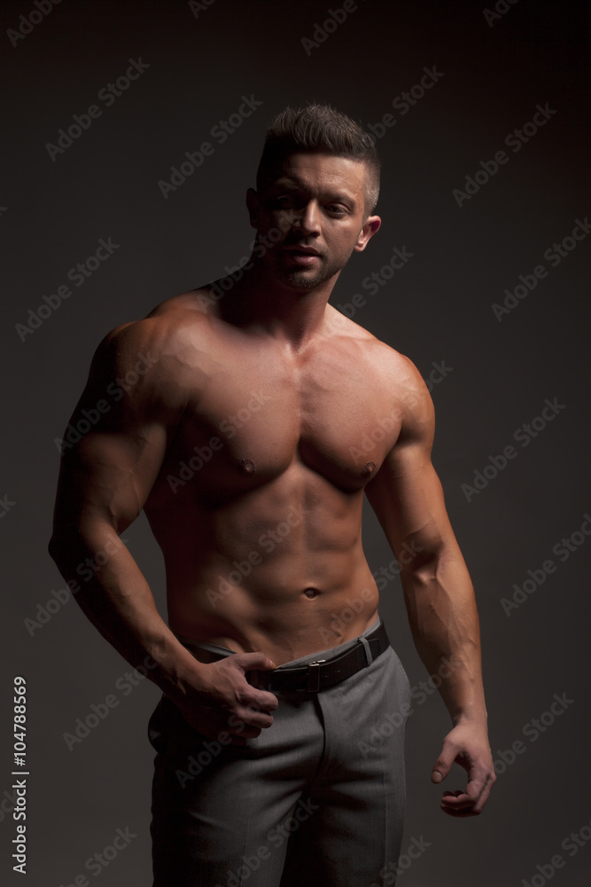 shirtless muscular man in pants posing in studio shirtless muscular man in pants posing in studio
