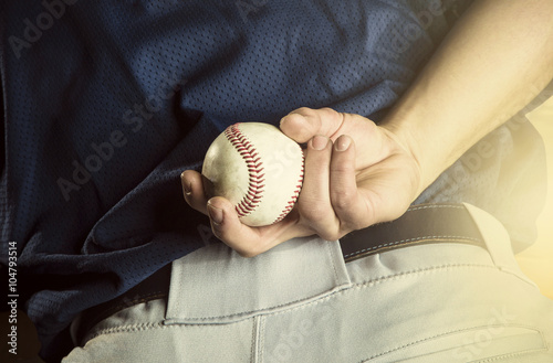 Baseball pitcher ready to pitch. Close up of hand focus on the fingers and the ball photo